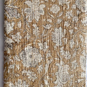 May include: A brown and white floral kantha quilt with a traditional Indian design. The quilt is made of cotton and is hand-stitched.