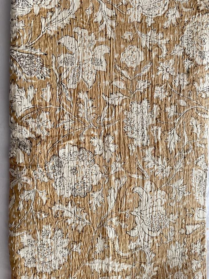 May include: A brown and white floral kantha quilt with a traditional Indian design. The quilt is made of cotton and is hand-stitched.