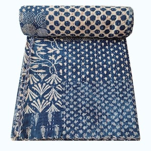 Könnte beinhalten: Eine blaue Kantha-Steppdecke mit Patchwork-Muster, das verschiedene weiße Muster zeigt, darunter Kreise, Blumen und Blätter.
