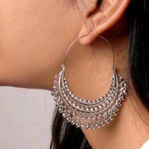 May include: Silver hoop earrings with a beaded fringe design.