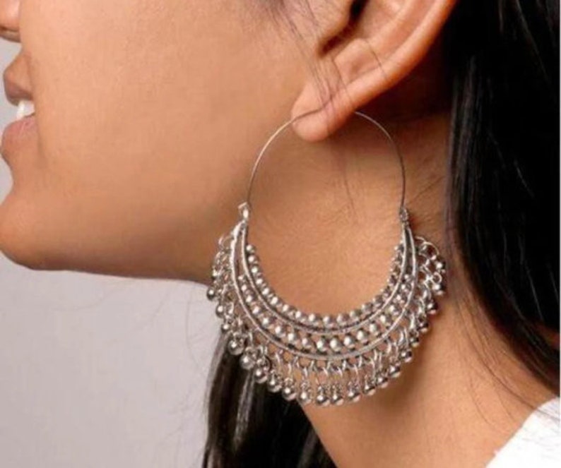 May include: Silver hoop earrings with a beaded fringe design.