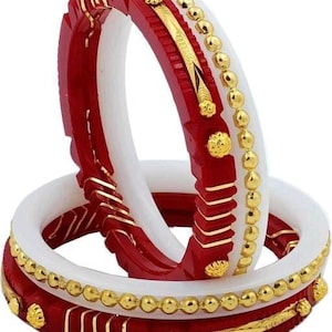 Op de afbeelding: Twee rode en witte armbanden met gouden accenten. De armbanden zijn versierd met een parelmoerpatroon en ingewikkelde patronen.