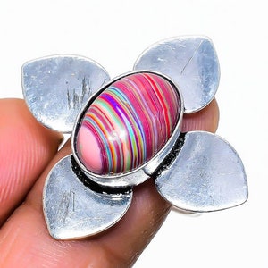 Puede incluir: Un anillo de plata con una piedra preciosa multicolor con rayas engastada en un diseño de flor.