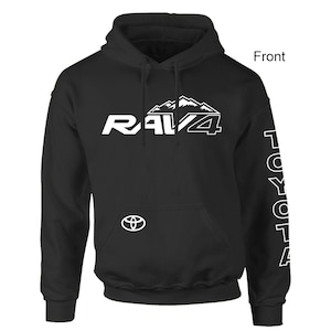 May include: Black hooded sweatshirt with white "RAV4" text and mountain graphic on the front. The Toyota logo is below the text. The right sleeve has the word "TOYOTA" in white. A front view of the sweatshirt is shown.