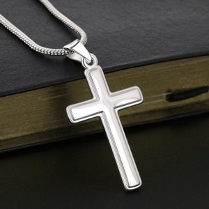 Pu&ograve; includere: Una collana a catena d'argento con un ciondolo a forma di croce d'argento. La croce &egrave; semplice e ha una finitura liscia e lucida.