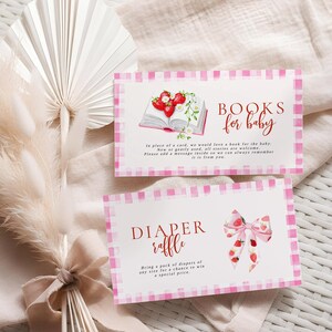 Könnte beinhalten: Zwei Babyparty-Einladungskarten mit rosa Vichy-Bordüren. Eine Karte trägt die Aufschrift "BOOKS for baby" mit einer Erdbeer-Illustration. Die andere sagt "DIAPER raffle" mit einer Schleifen-Illustration. Beide Karten haben roten Text.