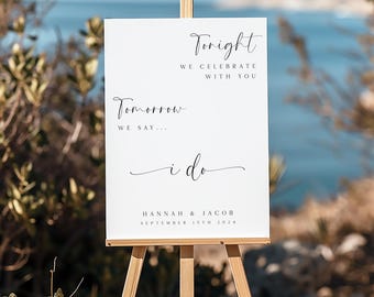 May include: A white wedding sign on a wooden easel with the text "Tonight we celebrate with you", "Tomorrow we say... i do", and the names "Hannah & Jacob" with the date "September 15th 2024".