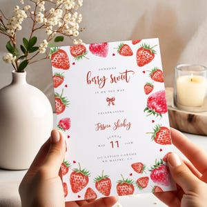 Könnte beinhalten: Eine weiße Einladungskarte mit Erdbeermuster und dem Text "Someone berry sweet is on the way". Die Karte ist mit Aquarell-Erdbeeren und Herzen verziert. Die Einladung ist für Jessica Shuhy, Sonntag, 11. Mai.