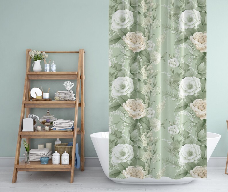 K&ouml;nnte beinhalten: Eine wei&szlig;e Badewanne mit einem gr&uuml;nen floralen Duschvorhang mit wei&szlig;en und cremefarbenen Rosen. Im Hintergrund befindet sich ein Holzregal mit verschiedenen Badezimmerartikeln.