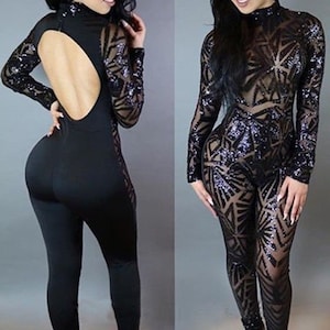 Op de afbeelding: Zwarte jumpsuit met lange mouwen en een transparante, met pailletten bezette overlay. De jumpsuit heeft een lage rug en een aansluitende pasvorm.