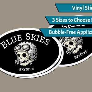 Könnte beinhalten: Zwei schwarze und weiße ovale Vinyl-Aufkleber mit einem Totenkopf, der einen Helm und eine Schutzbrille trägt. Der Text "BLUE SKIES" befindet sich über dem Totenkopf und "SKYDIVE" darunter. Die Aufkleber befinden sich auf einem hellbraunen Hintergrund. Vinyl-Aufkleber, 3 Größen zur Auswahl, Blasenfreie Anwendung.