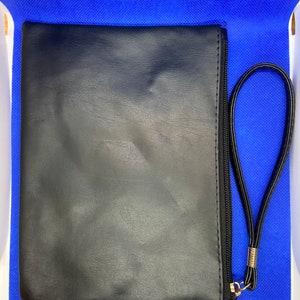 May include: A black leather zippered pouch with a gold zipper pull and a black strap.