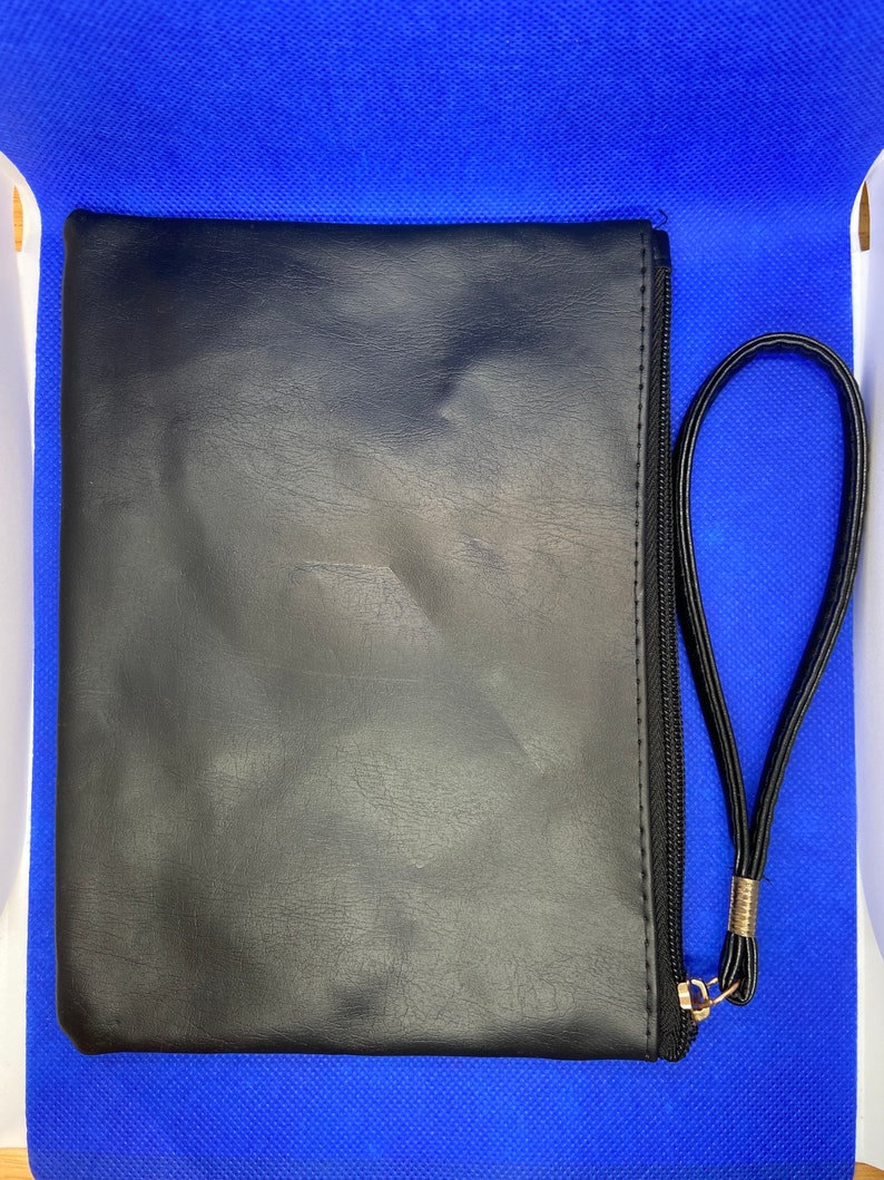 May include: A black leather zippered pouch with a gold zipper pull and a black strap.