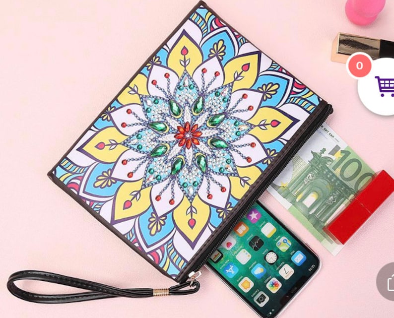 May include: A colorful zippered pouch with a mandala design. The pouch has a black zipper and a black strap. The pouch is open and has a phone and money inside.