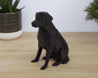 May include: A black, geometric, 3D printed sculpture of a dog sitting. The sculpture is made of many small triangles and has a realistic appearance.