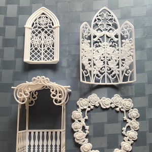 May include: Set of four white plastic dollhouse furniture pieces: a gazebo with a railing, a window, a screen, and a heart-shaped rose garland.