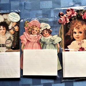 May include: Three vintage-style magnetic shopping list pads with images of girls and roses. Each pad has a lined notepad attached.
