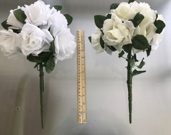 May include: Two bouquets of white artificial roses with green leaves and stems. The bouquets are arranged in a vase and are approximately 12 inches tall.