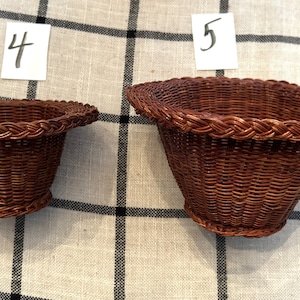 May include: Two brown wicker baskets with a braided rim. The basket on the left is labeled "4" and the basket on the right is labeled "5".