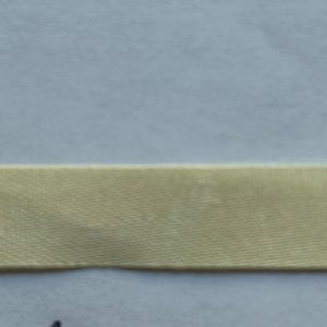 May include: A single strip of smooth, light gold-colored ribbon with a subtle sheen and a tightly woven texture. The ribbon is positioned horizontally across the frame, displaying a consistent width and a flat, uniform appearance throughout its length.