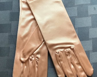 May include: A pair of long, peach-colored satin gloves. The gloves are folded in half and the fingertips are visible.
