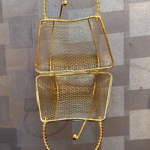 May include: A gold wire mesh basket with two sections and a handle. The basket is open and the wire mesh is visible.