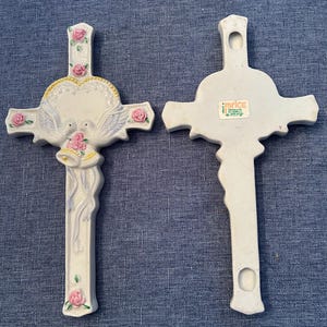 May include: White ceramic cross with a heart, doves, and wedding bells. The back of the cross has a "Price" sticker with the text "Products of the World, Inc.  Made in Taiwan".