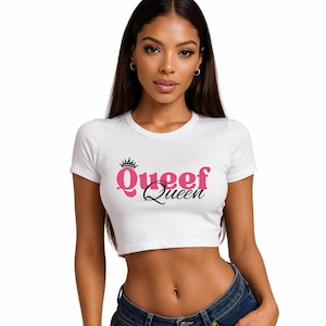 May include: White crop top with the text "Queef Queen" in pink and black, with a small crown above the word "Queef". The shirt has short sleeves and a round neckline.