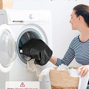 Puede incluir: Una lavadora blanca con una prenda negra en su interior. Una mujer est&aacute; colocando una cesta de ropa en la lavadora. El texto de la imagen dice "Machine-Washable Resists wrinkles and shrinkage, not lose quality Note: Wash with brunet cloth, bleaching, dry cleaning and tumble drying are not allowed."