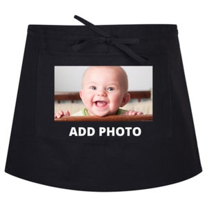 May include: Black apron with a pocket featuring a photo of a smiling baby. The text "ADD PHOTO" is printed below the photo.