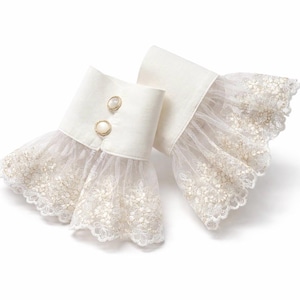 May include: A pair of off-white detachable cuffs featuring a structured fabric band with two round, gold-rimmed buttons. The cuffs are finished with a wide, flared layer of sheer, floral-embroidered lace that extends outward with a scalloped edge.