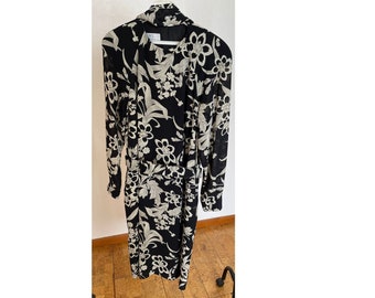 May include: A black and white floral print long-sleeved dress with a tie belt.