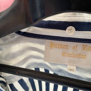 May include: A white and blue striped shirt with a label that reads "Prince of Roma Exclusiva" and a size tag that says "40".