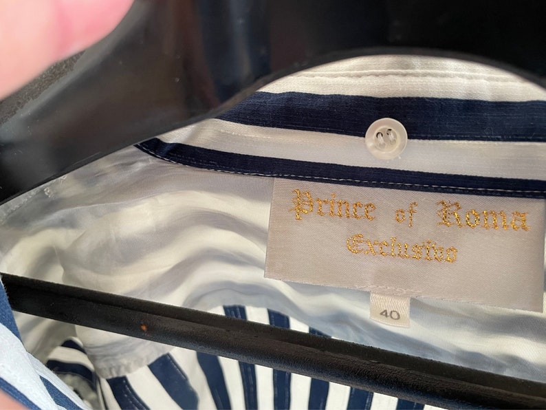 May include: A white and blue striped shirt with a label that reads "Prince of Roma Exclusiva" and a size tag that says "40".