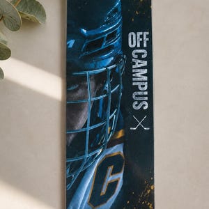 Könnte beinhalten: Ein rechteckiges Lesezeichen mit einer dunklen, stimmungsvollen Grafik eines Eishockeyspielers, der einen Helm mit Gitter und ein Trikot mit dem Buchstaben C trägt. Der Text OFF CAMPUS ist vertikal in Weiß gedruckt, ergänzt durch ein kleines Eishockeyschläger-Symbol.