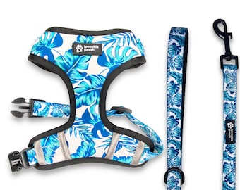 May include: A blue and white tropical leaf print dog harness and leash set with the text "loveable pooch" on the harness.