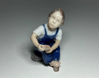 Bing and Grondahl Porcelain Figurine Boy with Shoe ‘Help Me, Mum’, Bing and Grøndahl Porcelain Figurine #2275 by Michaela Ahlmann