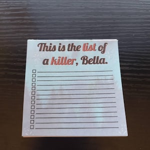 May include: A square notepad with the text "This is the list of a killer, Bella." in a mix of brown and black fonts. The notepad has a light blue background with a watercolor effect and a checklist on the left side.