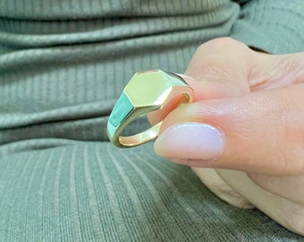 May include: A gold signet ring with a hexagonal face.