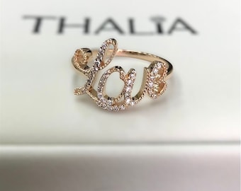 Anillo de oro rosa de 14k con diamante y diseño de amor en letra cursiva.