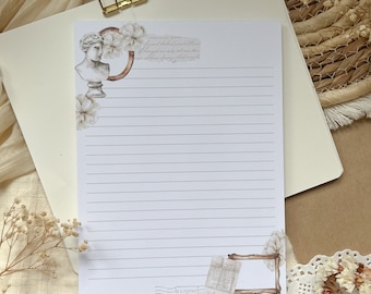 Può includere: Un blocco note bianco con righe e un bordo decorativo con un busto di donna, fiori e un francobollo vintage. Il testo "U.S. POSTAGE PAID 8¢ 9-10" è stampato sul francobollo.