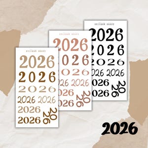 Könnte beinhalten: Drei Stickerbögen mit dem Jahr "2026" in verschiedenen Schriftarten und Farben. Die Bögen sind weiß mit Text in Braun-, Roségold- und Schwarztönen. Die Worte "STICKER SHEET" sind oben auf jedem Bogen aufgedruckt.