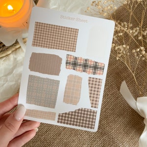 Könnte beinhalten: Eine Blatt mit braunen, beigen und roten gemusterten Aufklebern mit einem zerrissenen Randdesign. Das Blatt trägt den Text "Sticker Sheet" oben.