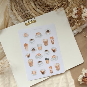 Könnte beinhalten: Eine Sticker-Tabelle mit verschiedenen Illustrationen von Kaffee und Latte. Die Sticker sind in Braun-, Beige- und Weißtönen gehalten. Die Tabelle trägt oben die Aufschrift "Sticker Sheet".