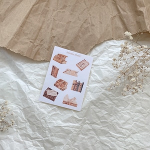Könnte beinhalten: Eine Sticker-Tabelle mit verschiedenen Illustrationen von alten Büchern. Die Tabelle ist weiß mit dem Schriftzug "Sticker Sheet" in Schwarz oben.