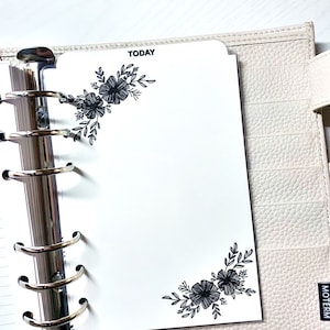 May include: A white planner with a silver binder and black floral designs. The planner has the word "TODAY" printed at the top.