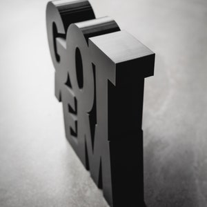 Peut inclure: Lettres 3D noires &eacute;pellant "GOT 'EM" pos&eacute;es sur une surface grise.