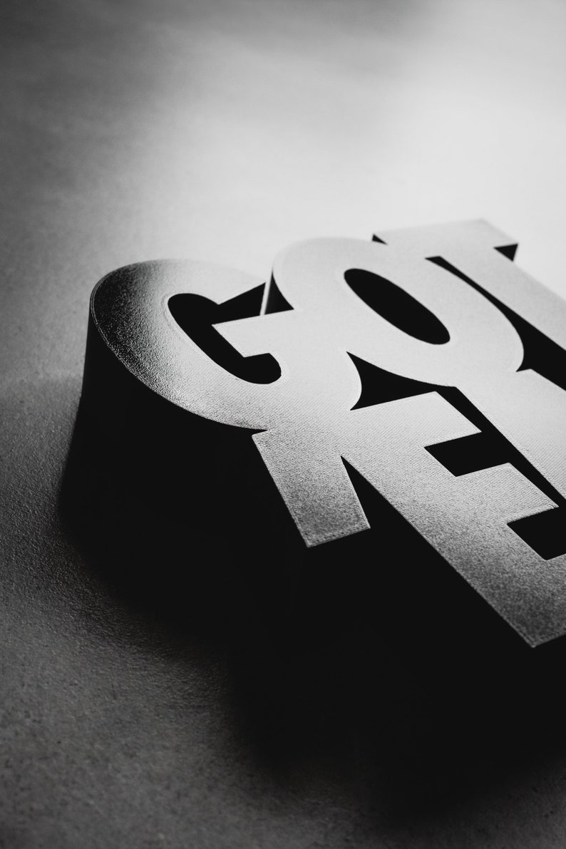 Peut inclure: Gros plan sur le mot "GOT" en lettres blanches en gras sur un fond noir. Les lettres sont en trois dimensions et ont une finition brillante.