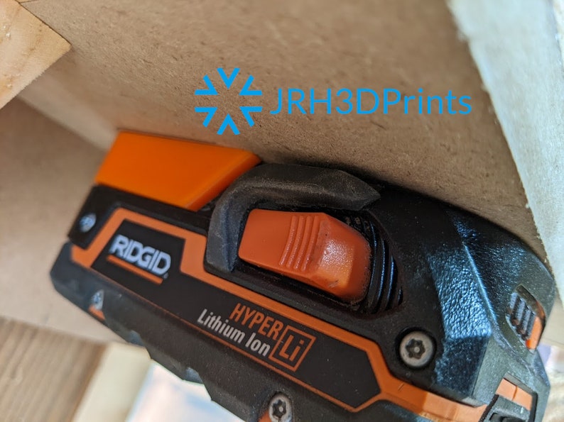 K&ouml;nnte beinhalten: Nahaufnahme eines schwarzen und orangefarbenen Elektrowerkzeugs mit dem Markennamen "RIDGID" und dem Text "HYPER Li Lithium Ion" an der Seite. Das Werkzeug hat einen orangefarbenen Ausl&ouml;ser und einen schwarzen Griff.