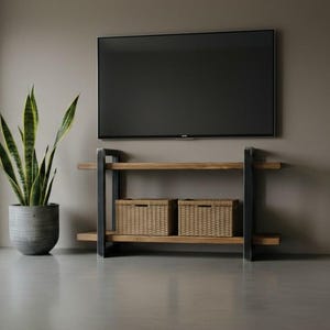 Può includere: Un tavolo consolle rettangolare in legno con due ripiani e una struttura in metallo nero, dotato di due cesti portaoggetti in vimini intrecciato sul ripiano inferiore. Una pianta di sansevieria verde alta in un vaso grigio si trova a sinistra.